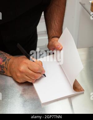 La dedizione del libro con pagina vuota sul tavolo da cucina. Foto Stock