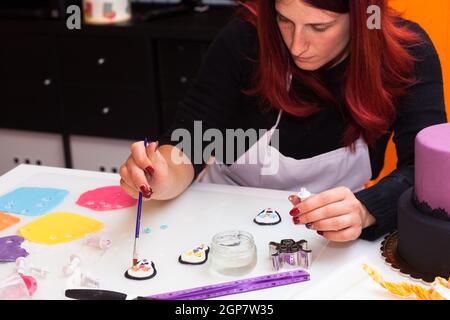 Lezione di pasticceria, lavorando sulle figure di Halloween con fondente di pasta o di pasta di zucchero. Foto Stock