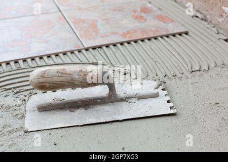 Spatola dentellata per applicazione di adesivi per piastrelle. Foto Stock