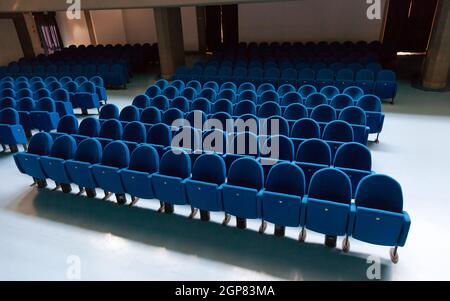 Righe di colore rosso sedie teatro nella sala conferenza. Foto Stock