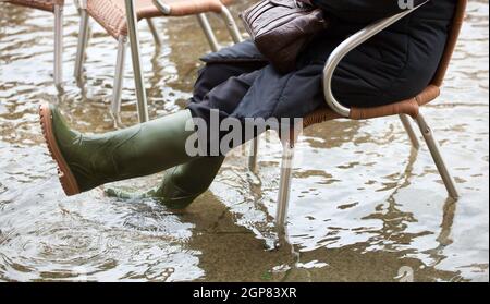 Close Up di gambe con scarponi dovuta all'acqua alta. Questo flusso si verifica quando vi è alta marea a Venezia, Italia. Foto Stock