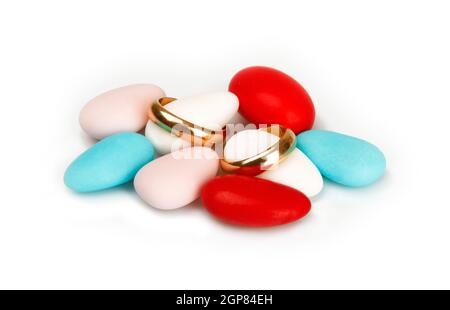 Coriandoli colorati con gli anelli di nozze su sfondo bianco. Foto Stock