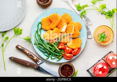 Deliziosi bocconcini di pollo fritti con cowpea sul piatto Foto Stock