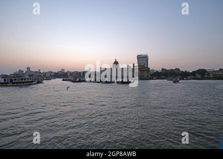 Taj Mahal Hotel, Gateway of India e barche turistiche in acqua del Mar Arabico al tramonto a Mumbai, India Foto Stock