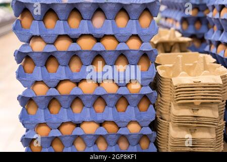 Pila di uova di pollo in vassoi di carta blu uno sopra l'altro per la vendita al supermercato, Inghilterra Regno Unito Foto Stock