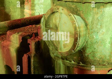 Scantinato di una stazione di pompaggio di acqua. Abbandonato il post-apocalittico vista del seminterrato camere di pompaggio. Perdita nel portello sul tubo. Le vecchie apparecchiature. Foto Stock