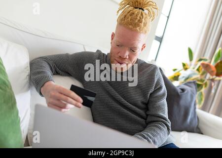 Albino african american uomo nel soggiorno shopping online Foto Stock