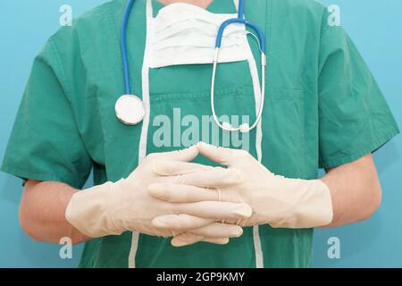 Il chirurgo spiega il medico del metodo chirurgico nei vestiti di op e nei guanti di gomma con il gesto di spiegazione Foto Stock