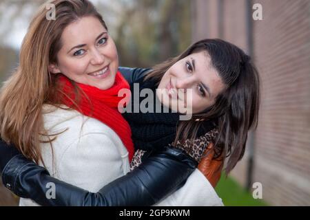 VAALS, POLONIA - 04 novembre 2010: Una donna che indossa una sciarpa rossa e un amico con una giacca in pelle in un parco. Foto Stock