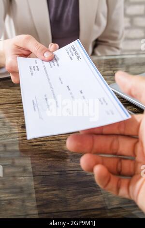 Assegno di denaro o assegno di pagamento per mano Foto Stock