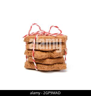 pila di biscotti di pan di zenzero al cioccolato a forma di stella legati con corda rossa e isolato su sfondo bianco Foto Stock
