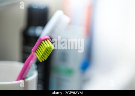 Spazzolino da denti colorati in bagno, routine mattutina Foto Stock