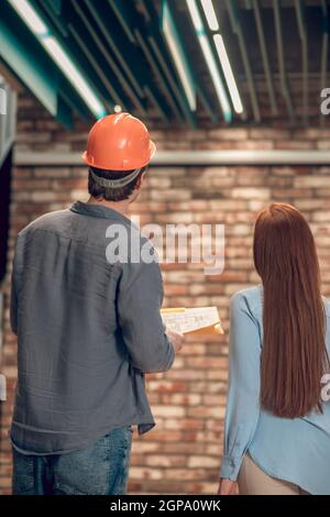 L'uomo e la donna meditando davanti al muro di mattoni Foto Stock