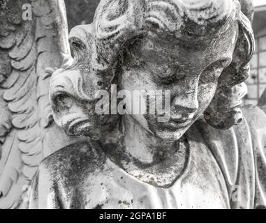 Immagine in bianco e nero di antica statua in pietra di angelo triste. Religione, fede, morte, risurrezione, concetto di eternità. Foto Stock