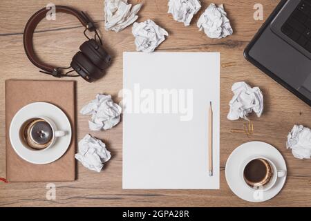 Carta sminuzzata sparsa, tazze vuote di caffè sul tavolo di un lavoratore creativo. Crisi creativa. Concetto di stress, problemi di salute mentale e mancanza di me Foto Stock