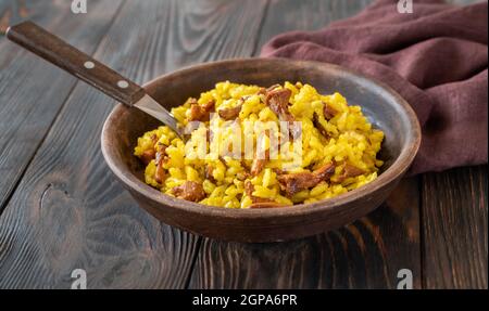 Porzione di risotto allo zafferano con chanterelle fritte Foto Stock