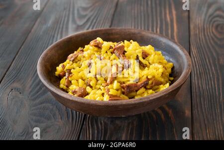 Porzione di risotto allo zafferano con chanterelle fritte Foto Stock