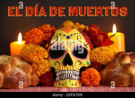 Pane dei morti e cranio dipinto con fiori marigolenti su sfondo scuro. Celebrazione della Giornata dei morti del Messico (El dia de Muertos) Foto Stock