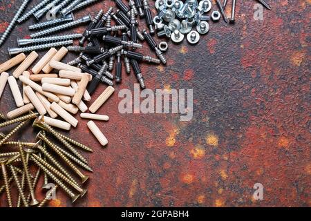 Set di dadi, bulloni, viti, chiodi e tasselli diversi su sfondo colorato Foto Stock