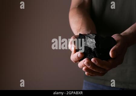 Carbone nero in mani maschili, primo piano Foto Stock