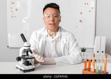 Insegnante asiatico che conduce la lezione di chimica Foto Stock