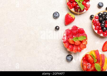 Composizione con gustosi tartine di bacche su sfondo grunge Foto Stock