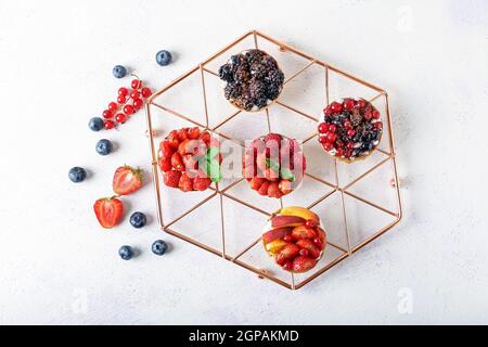Composizione con gustosi tartine di bacche su sfondo chiaro Foto Stock