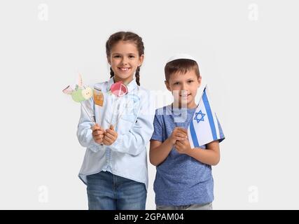 Bambini piccoli con bandiera di Israele e arredamento per Rosh Hashanah (Capodanno ebraico) su sfondo bianco Foto Stock