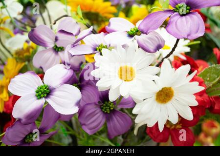 Bouquet artificiale colorato con foglie, interior design una fila di bouquet in un negozio di fiori, decorazione artificiale tessuto fiore rosa bouquet sfondo Foto Stock