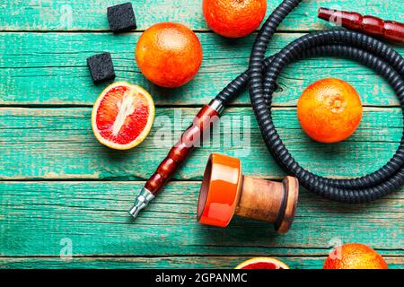 Hookah orientale fumatori o shisha con tabacco con pompelmo flavour.modern shisha di frutta con arancia Foto Stock