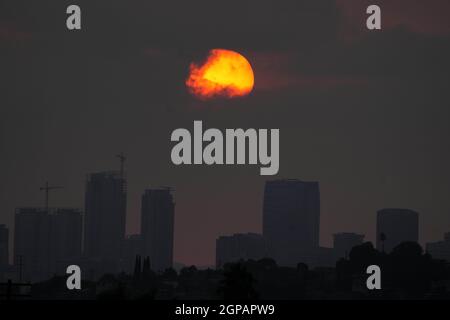 Il sole tramonta sullo skyline del centro in cieli oscurati da incendi selvatici, martedì 28 settembre 2021, a Los Angeles. Foto Stock