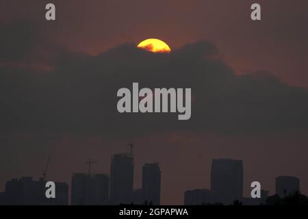 Il sole tramonta sullo skyline del centro in cieli oscurati da incendi selvatici, martedì 28 settembre 2021, a Los Angeles. Foto Stock