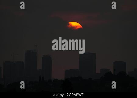 Il sole tramonta sullo skyline del centro in cieli oscurati da incendi selvatici, martedì 28 settembre 2021, a Los Angeles. Foto Stock