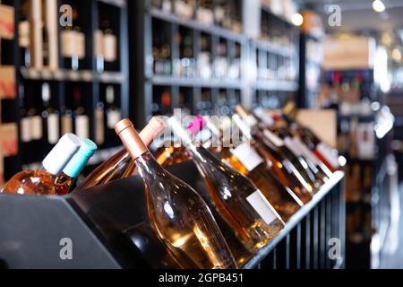 Rack con diverse bottiglie di vino in un moderno negozio di vini in attesa per i clienti Foto Stock