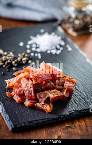 Carne di pollo essiccata. Gustosa carne a scatti sul tagliere. Foto Stock