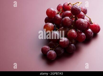 Globo rosso con gocce d'acqua poste su uno sfondo rosso scuro opaco con spazio. Foto Stock