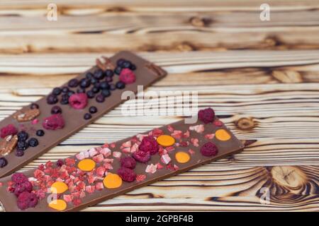 diversi tipi di cioccolato con frutta secca su tavola di legno Foto Stock