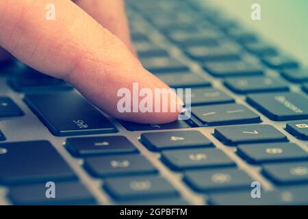 Singolo dito premere il tasto sulla tastiera del notebook Foto Stock