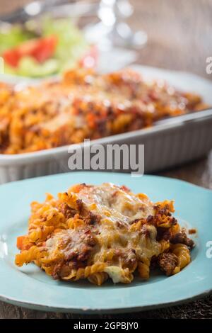 pasta gratinata con insalata su legno Foto Stock