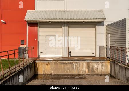 Storage porta per lo scarico del carico può essere usata come background industriale. Portelli di carico a magazzino o negozio di baia di carico Foto Stock