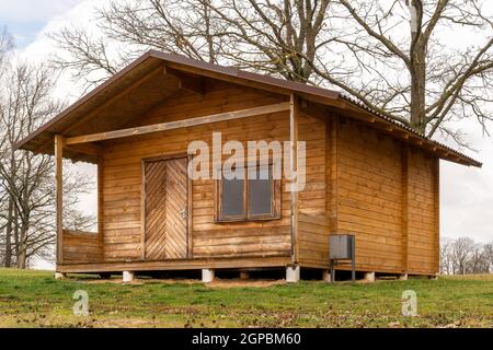 Piccola casa in legno in campagna durante la stagione autunnale Foto Stock