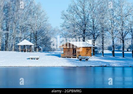 Summerhouse ecologico vicino al lago ghiacciato all'inizio dell'inverno Foto Stock