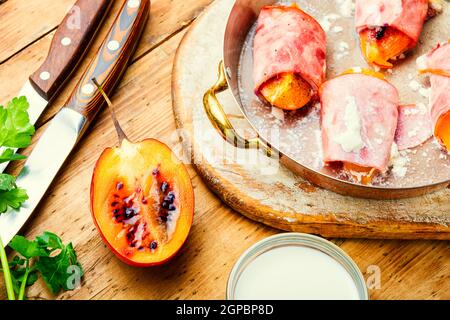 Pezzi di Tamarillo avvolti e cotti con prosciutto e pancetta Foto Stock