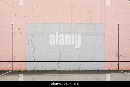 Parete di pelota basca screpolata, rosa e grigio. Foto Stock