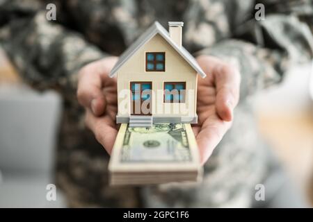 Programma SCRA. Esercito militare uomo in uniforme che tiene Nuova Casa Foto Stock