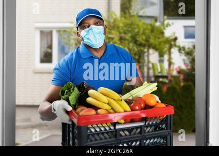 Drogheria alimentare consegna in Covid maschera viso Foto Stock