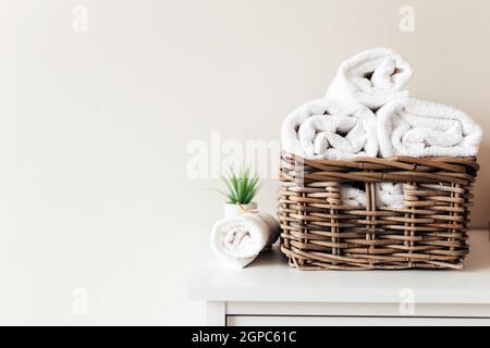 Cestino con accessori da bagno. Un set di asciugamani piegati e arrotolati. Concetto di pulizia dell'hotel. Foto di alta qualità Foto Stock