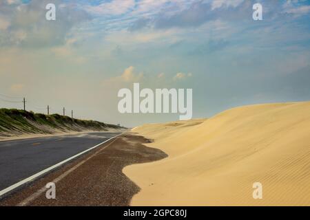 Le dune di sabbia si spostano lungo Ocean Boulevard a nord di South Padre Island, Texas. Foto Stock