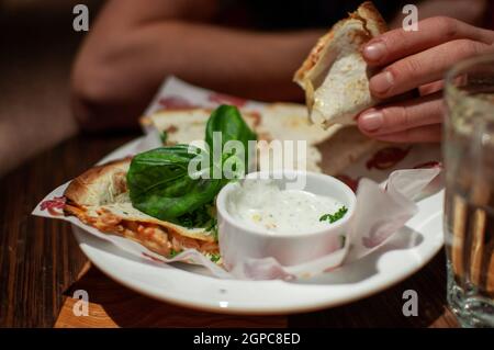 Uomo che mangia deliziosa quesadilla con bagno nel ristorante Foto Stock