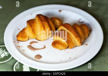 Piatto con due croissant decorato con crema di cioccolato in un ristorante Foto Stock